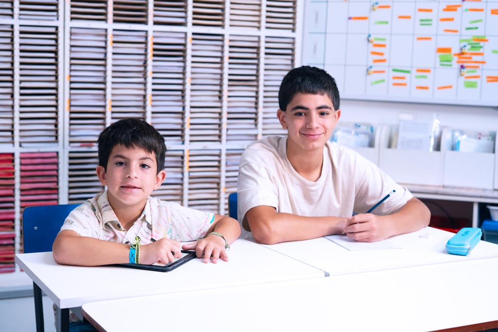 Dos alumnos en un centro Kumon, uno en la tableta y otro en el cuadernillo en papel-Argentina