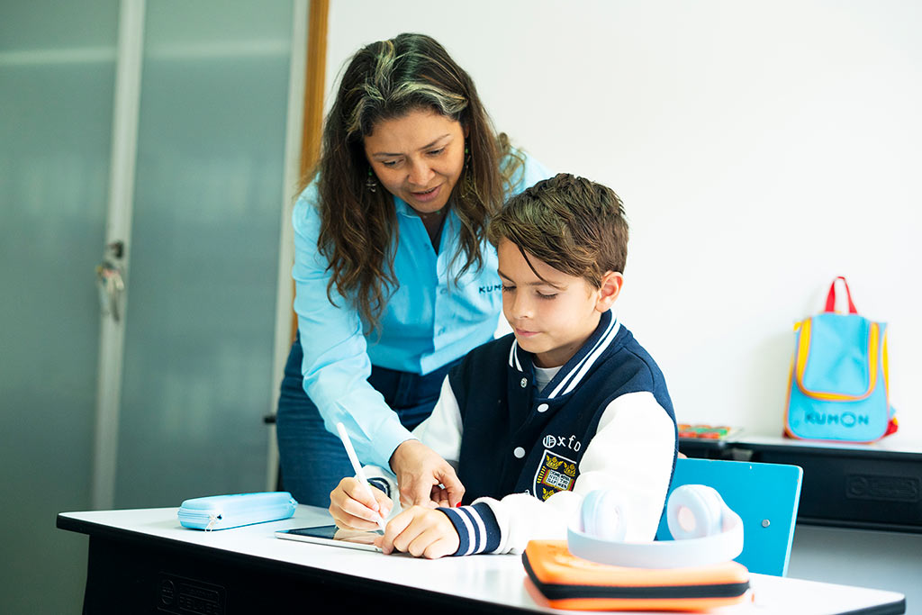 Orientadora de Kumon guiando a um alumno mientras trabaja en tableta-Argentina